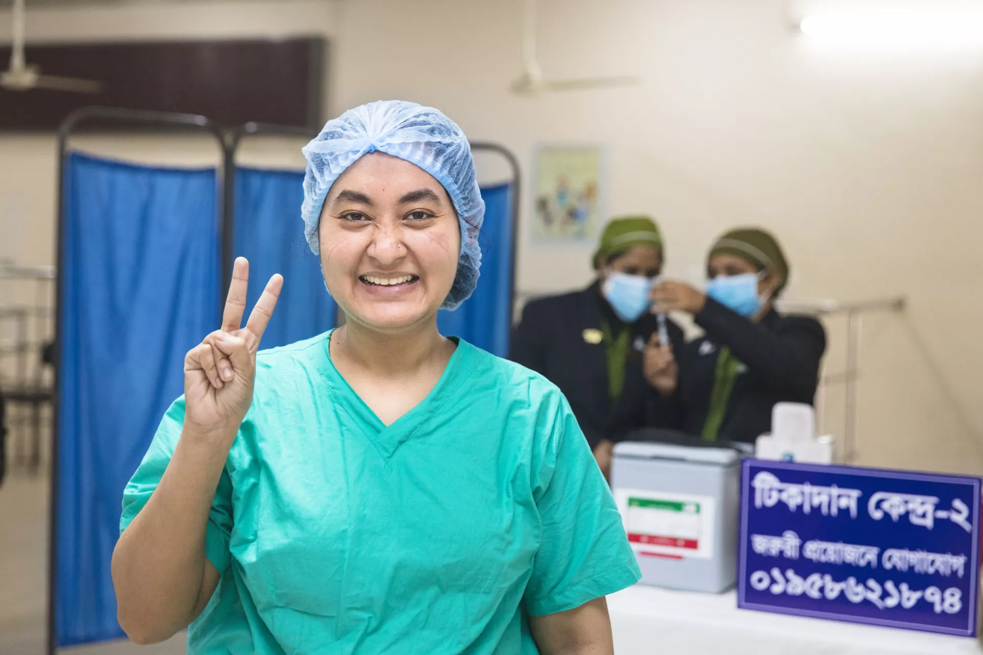 Nurse Ismat Jahan Sarker holds up the 'v' sign after receiving the COVID-19 vaccine at Kurmitola General Hospital in Dhaka, Bangladesh.