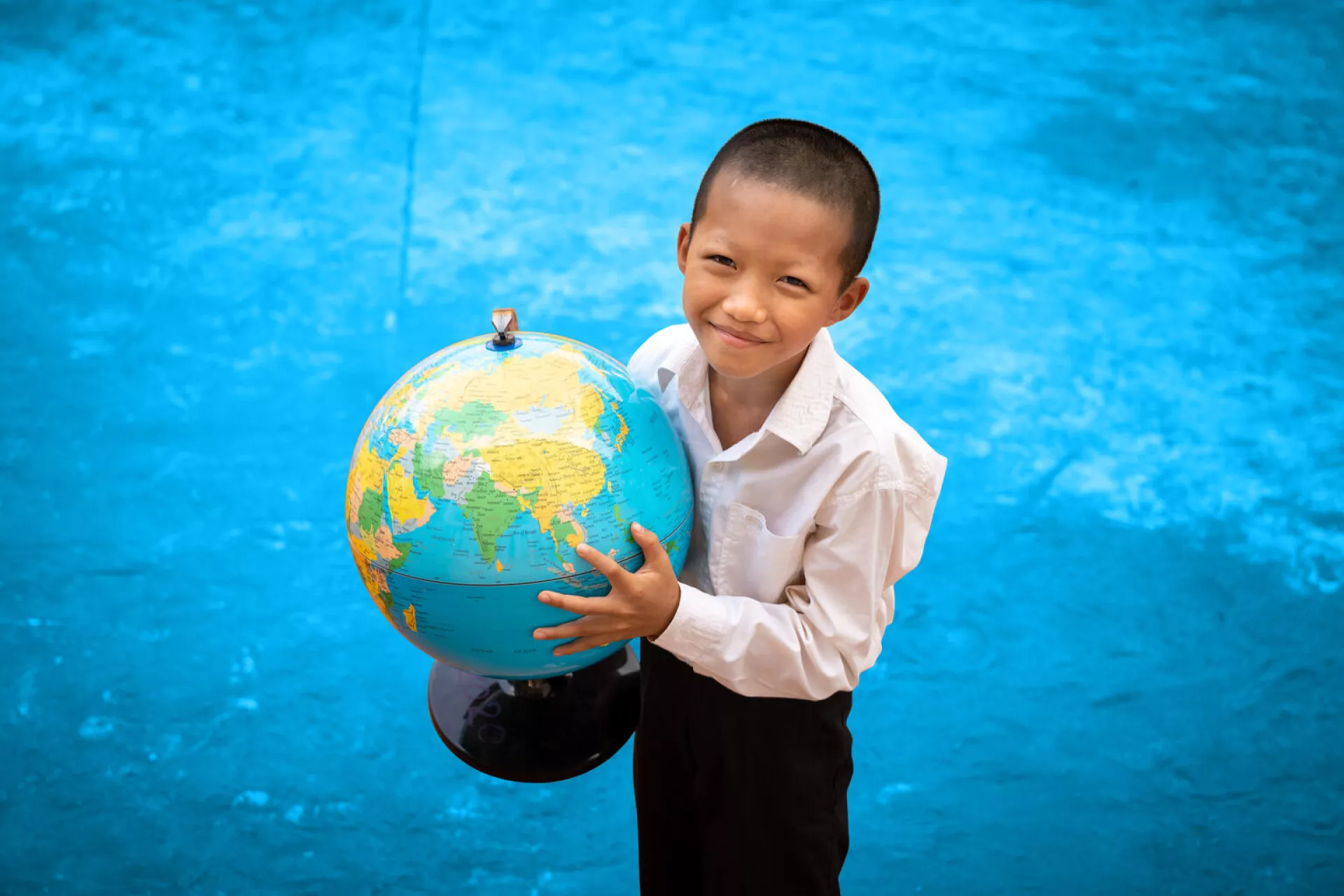 Convención sobre los Derechos del Niño - un niño sostiene un globo terráqueo