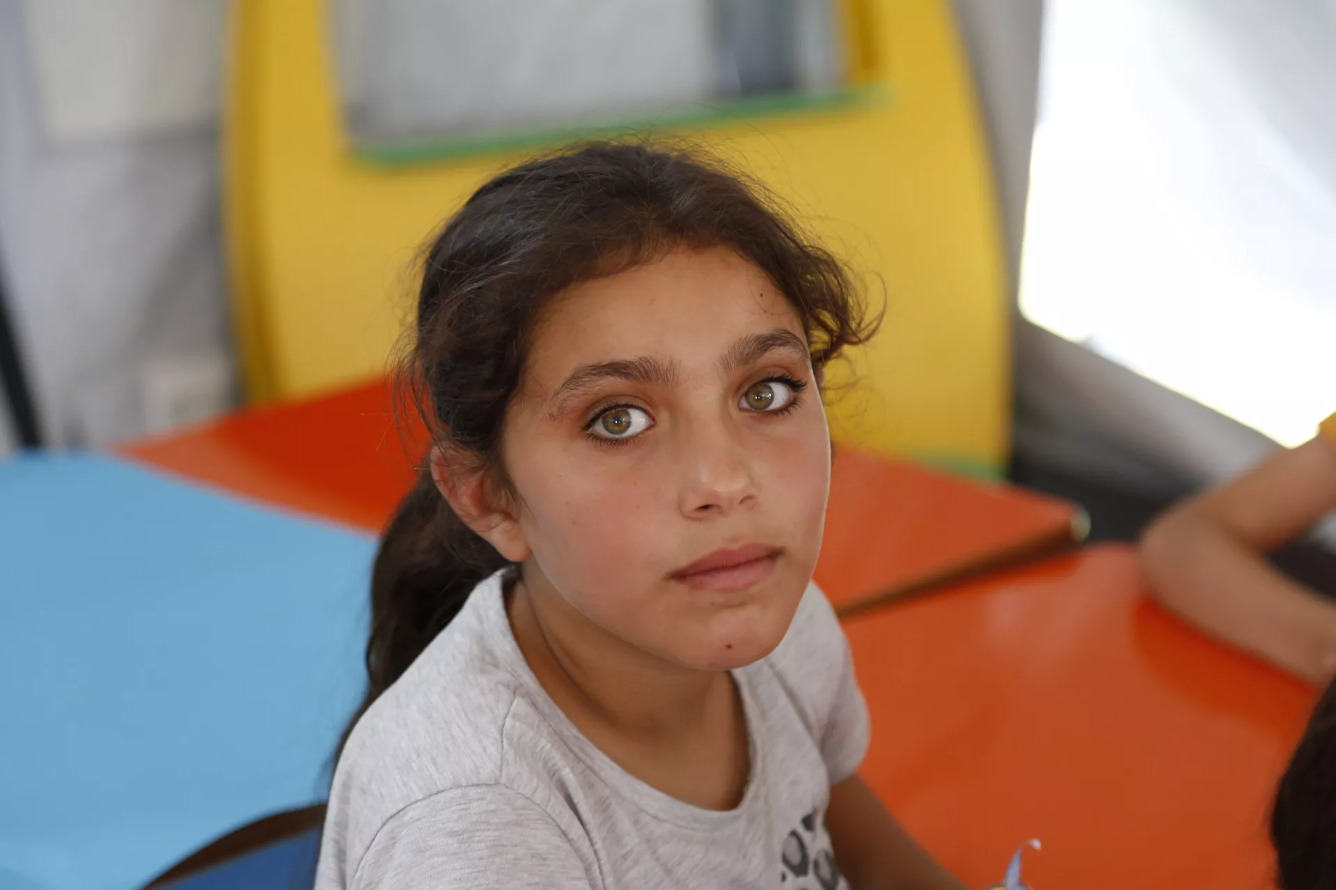 Una niña en un espacio acogedor para los niños en un albergue de alojamiento temporal en Turquía