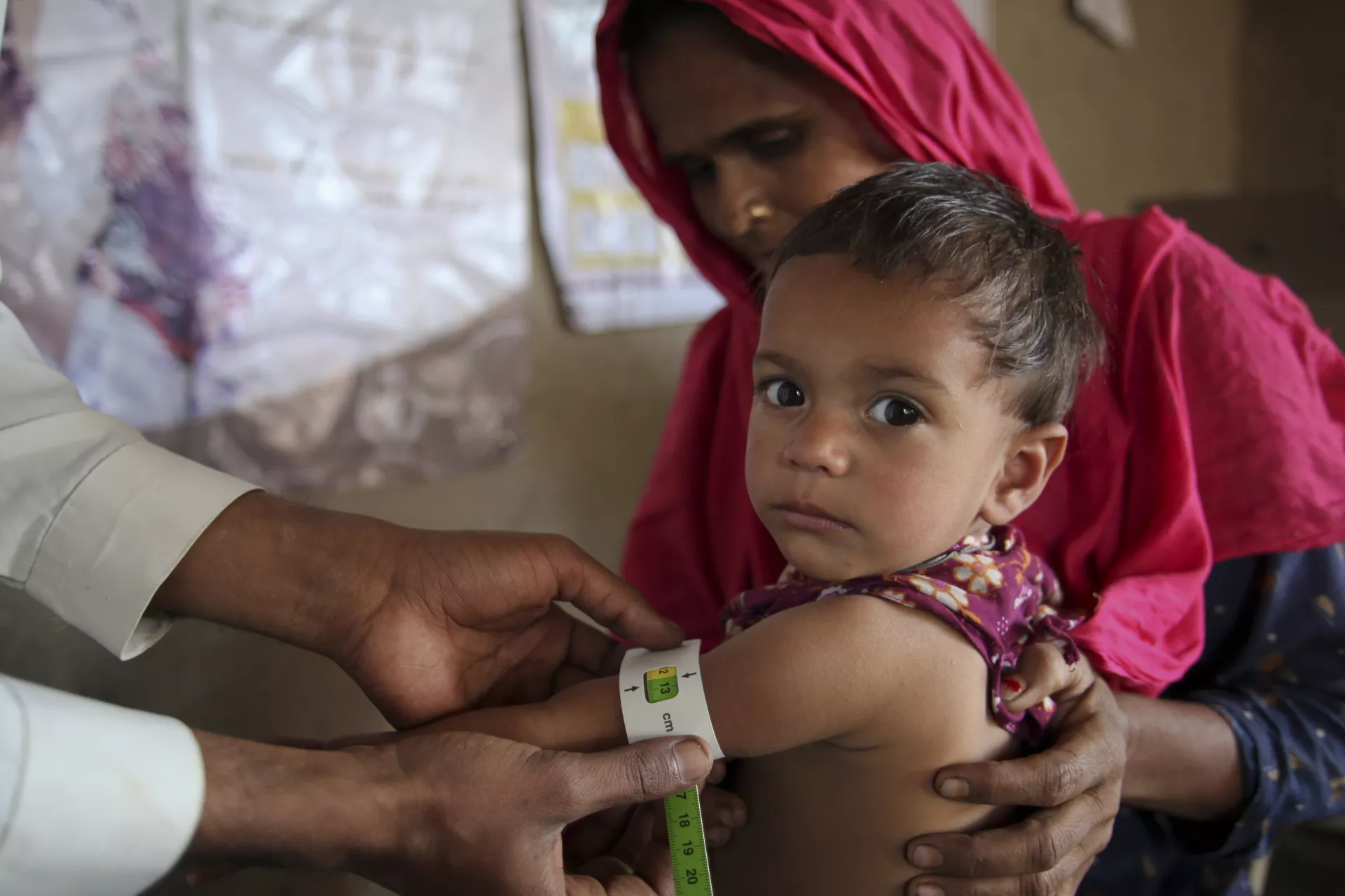 Pakistan. A child is checked for malnutrition.