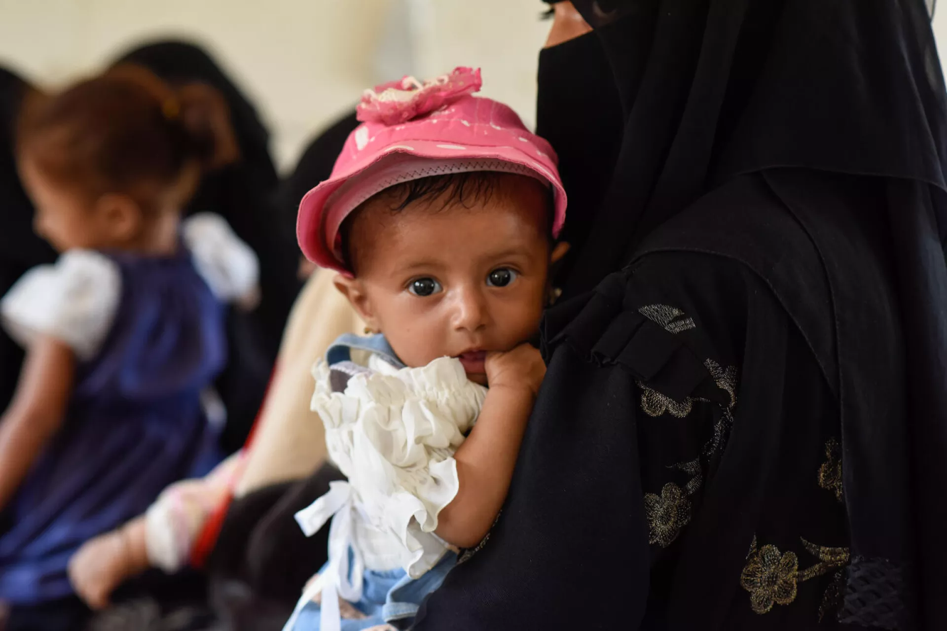 Yemen. A child is cradled in her mother's arms as she undergoes the required screenings and vaccinations at a mobile clinic team building project in Hajjah, Yemen.