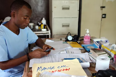 A health worker texts on his mobile phone, Sierra Leone