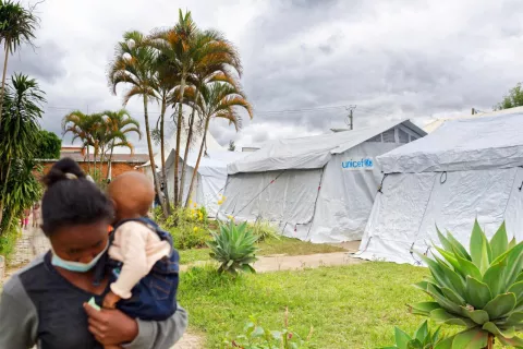 A girl and a child walk past UNICEF tents as UNICEF Madagascar prepares for Cyclone Batsirai. 