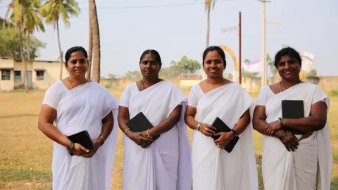 A group of Auxiliary Nurse Midwives (ANMs) in India holding tablets. 