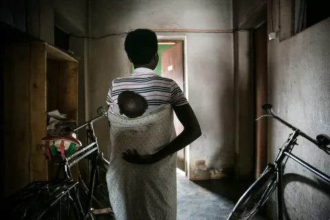 A girl carries a baby on her back, Burundi