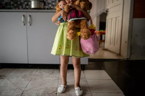 Four-year-old Mirjeta (name changed) holds her toys while getting ready to go out with her mother in Tirana, Albania, in June 2018. Mirjeta’s mother was physically and mentally abused by her husband, who became violent after discovering that she was pregnant with a girl. 