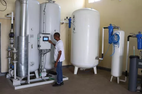 Uganda. A man stands next to an oxygen plant.