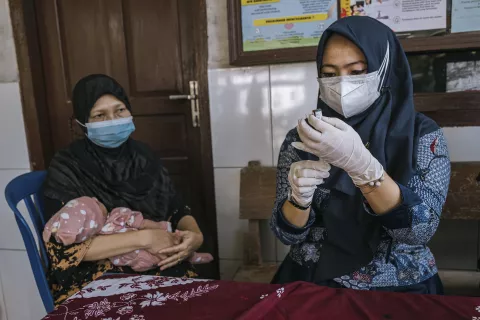 A health worker prepare to vaccinate a child at the Larangan Community Health Centre in Pamekasan, Indonesia.