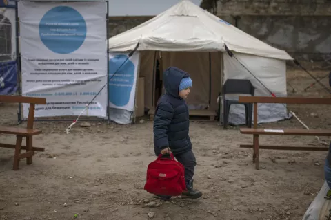 A boy walks past on March 16, 2022 outside a UNICEF-UNHCR Blue Dot centre at a refugee reception centre close to the Palanca border crossing in Moldova, near the Moldova-Ukraine border after they fled from the Ukrainian city of Odessa.