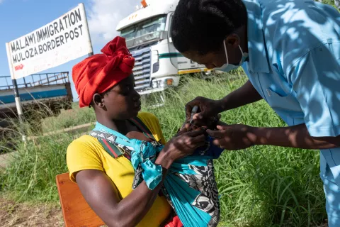 A health care worker from the Malawi Department of Health administers vaccines near the Mozambique-Malawi border crossing at Muloza Border Post near Mulanje, Malawi.