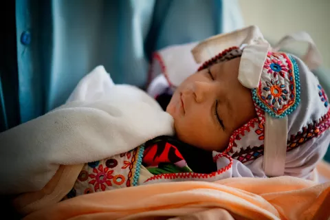 Una niña duerme la siesta en brazos de su madre en la sala de espera del Hospital Jannat Gul en el suburbio de Gujro. Como es el único centro de salud en el área, el hospital atiende a una gran cantidad de niños y familias todos los días.