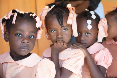 Haiti. Three girls line up waiting during a cholera vaccination campaign in Mirebalais.