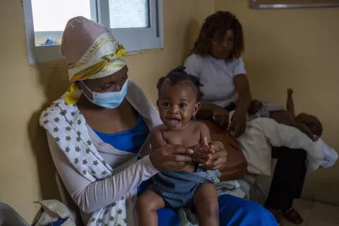 Nine-month-old Lwisani is held by her mother, Lidia Francisco, prior to receiving a dose of a measles and rubella vaccine at Catambor Health Centre in Luanda.