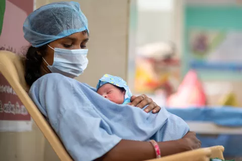 Dans un hôpital, une mère tient son nouveau-né dans ses bras.