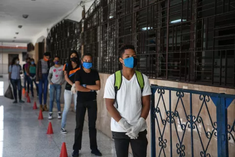 Venezuela. Students wearing facemasks line up outside their school.