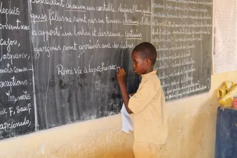 Student writes on the blackboard.