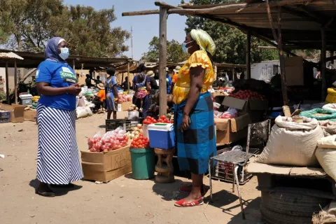 Zimbabwe. A woman stands near an outdoor market.