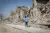 A child walks past damaged buildings in Iraq.