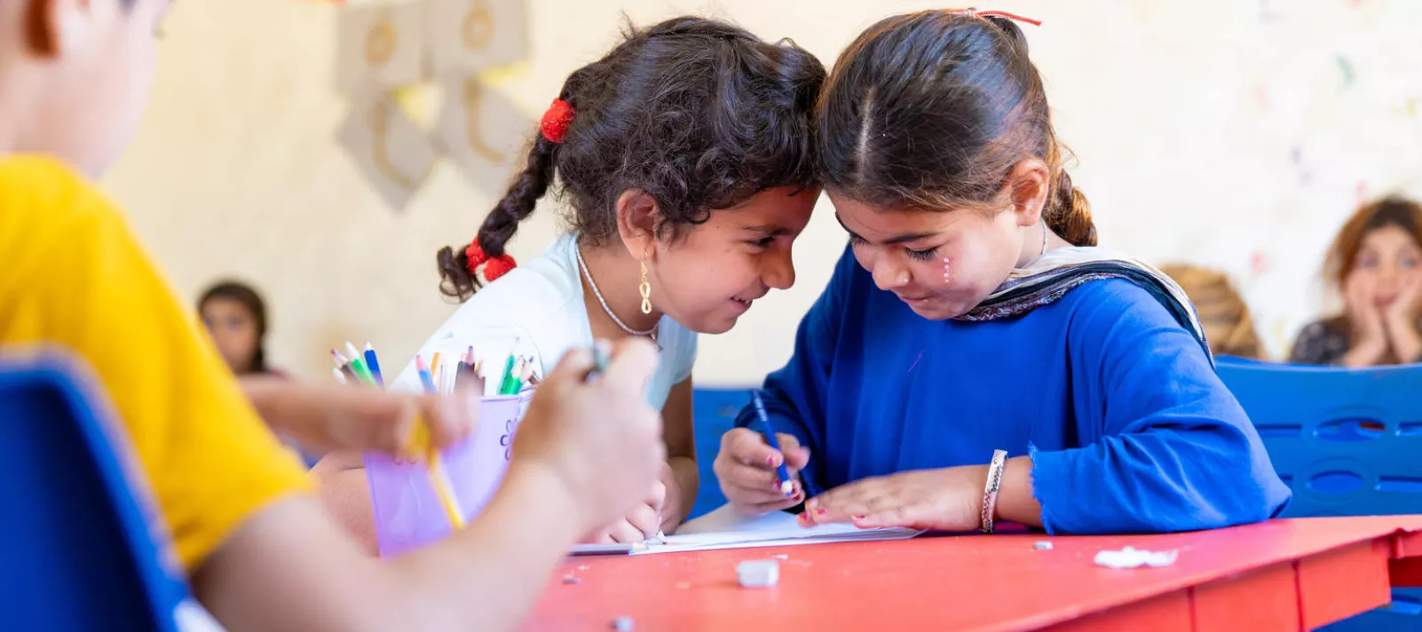 Yasmeen, 7, and Aisha, 7 (in dark blue), in their local Makani centre in Jordan, 2019. 