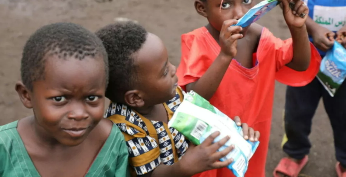 Young children drink from milk cartons 