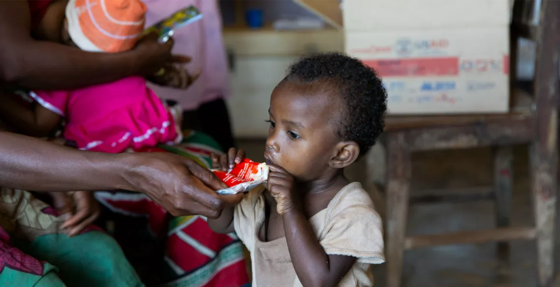 A child with severe wasting eats ready-to-use therapeutic food