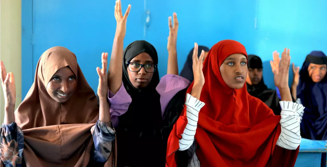 A group of female students practicing sign language