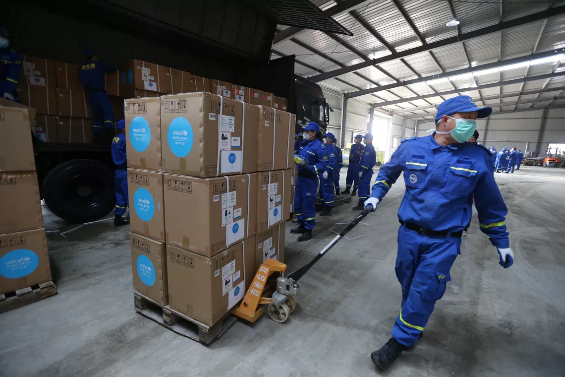 A volunteer pulls a cart of UNICEF donated supplies in an emergency warehouse of the Hubei Charity Foundation in Wuhan, China.
