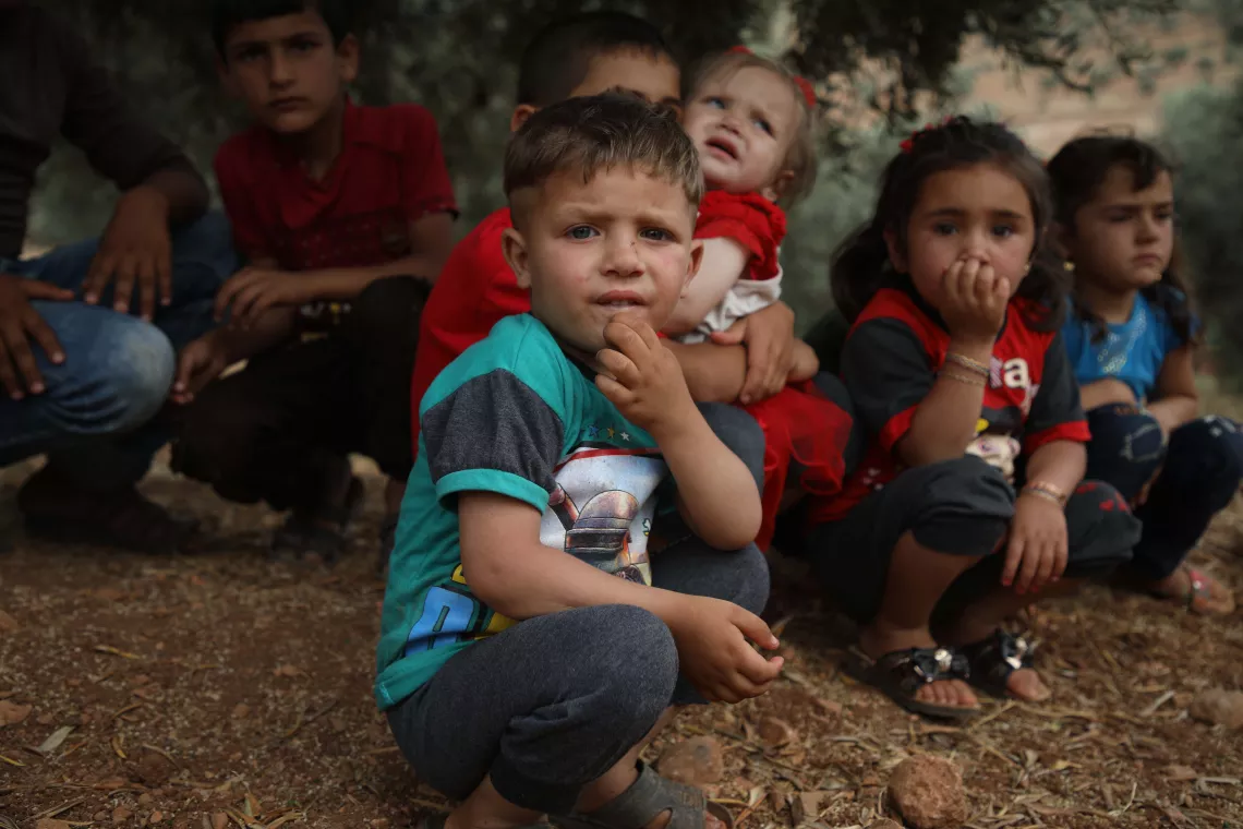 Syria. Children rest beneath a tree at a makeshift camp in Aqrabat village.