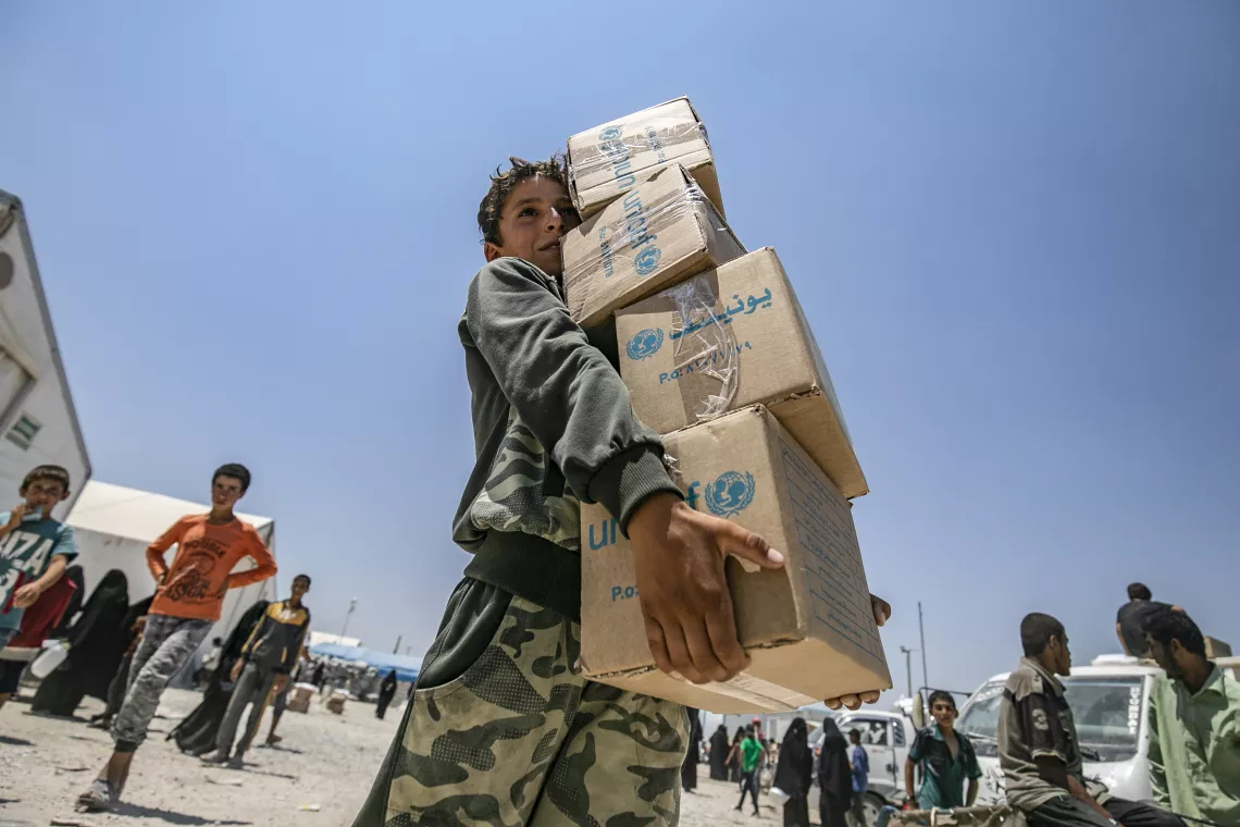 Syria. A boy collects a UNICEF-supported summer clothing kit at a camp in Al-Hol in northeast Syria.