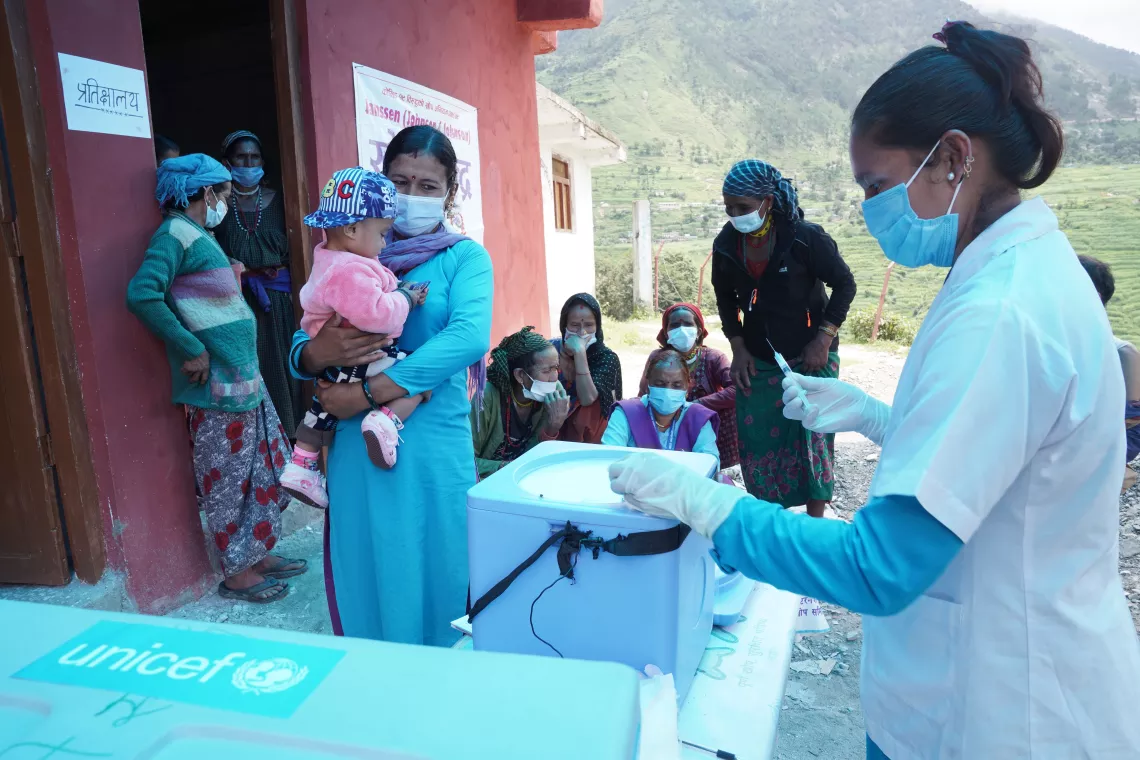 A health care worker delivers vaccines to a remote community in Nepal