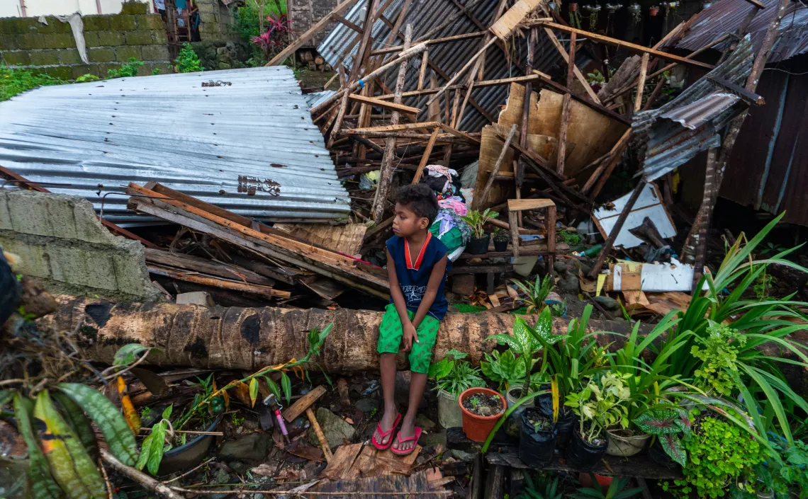 A child in Surigao City, in the Philippines, stands in front of a house destroyed by Typhoon Rai.