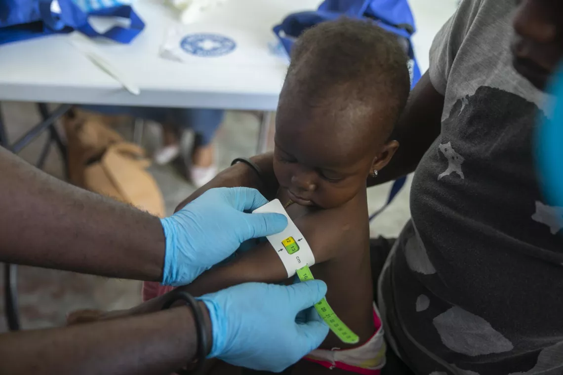 Haiti. A healthcare worker measures the upper arm circumference of a child at a UNICEF-supported clinic treating malnutrition in Port-au-Prince.