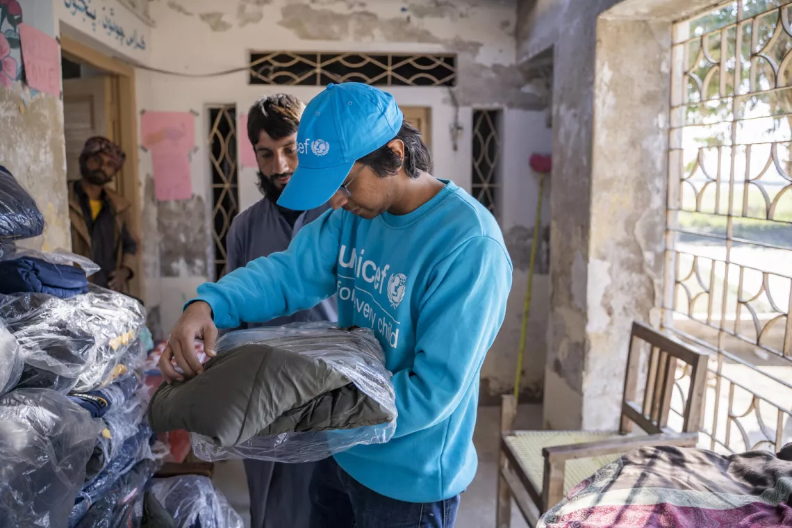 Pakistan. A UNICEF communications officer inspects jackets that are ready to be distributed among flood-affected children in Dadu District, Sindh Province.