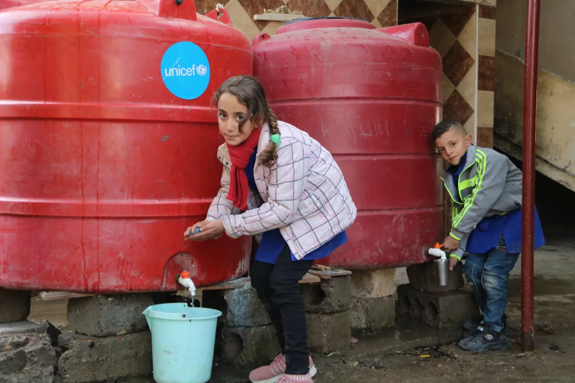 叙利亚哈特拉村的孩子们在联合国儿童基金会资助的抽水站洗手。