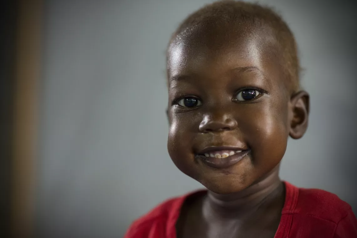 A young boy smiles after being treated for malnutrition and tuberculosis.