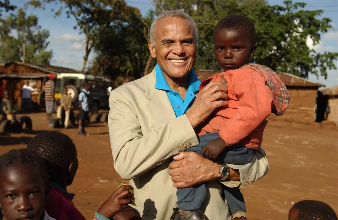 UNICEF Goodwill Ambassador Harry Belafonte holds a toddler, standing with other children in the Makina section of the Kibera shanty town in Nairobi, in 2004.