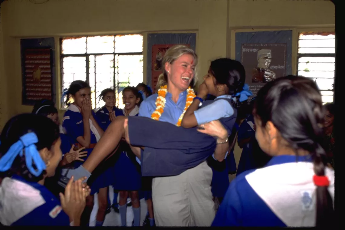 During recreational activities in a primary school class, UNICEF International Spokesperson Vendela Thommessen surprises a girl by picking her up, then joins in the common laughter, in New Delhi, India.