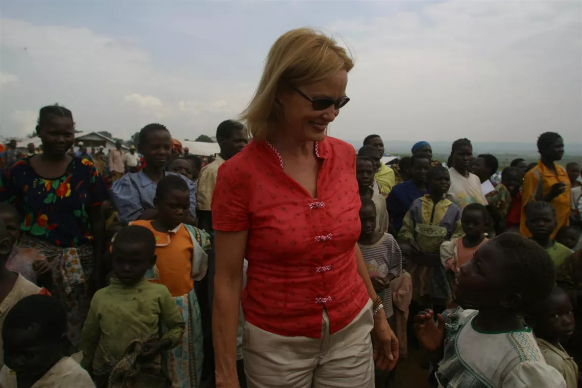 UNICEF Goodwill Ambassador Jessica Lange speaks with a girl, standing amidst a large group of other children in a camp for some 9,000 displaced people near the airport in the town of Bunia in the eastern region of Ituri, the Democratic Republic of the Congo.