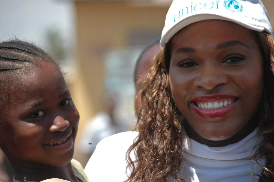 Tennis World Champion Serena Williams (centre) holds a girl at the Nungua-Zongo immunization site in Greater Accra during the national integrated child health campaign in Ghana, 2006.