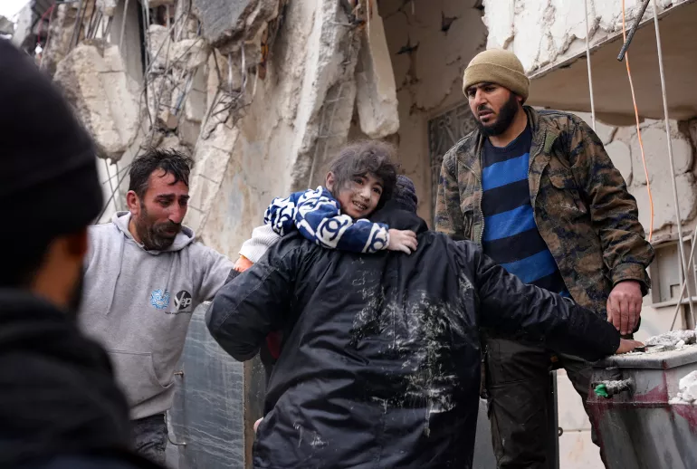 On 6 February 2023, residents retrieve a small child from the rubble of a collapsed building following an earthquake in the town of Jandaris, in the countryside of Syria's northwestern city of Afrin in the rebel-held part of Aleppo province. Hundreds have been reportedly killed in north Syria after a 7.8-magnitude earthquake that originated in Turkey and was felt across neighboring countries.