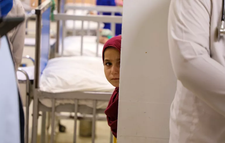 Kabul. A child looks around a corner in a hospital.