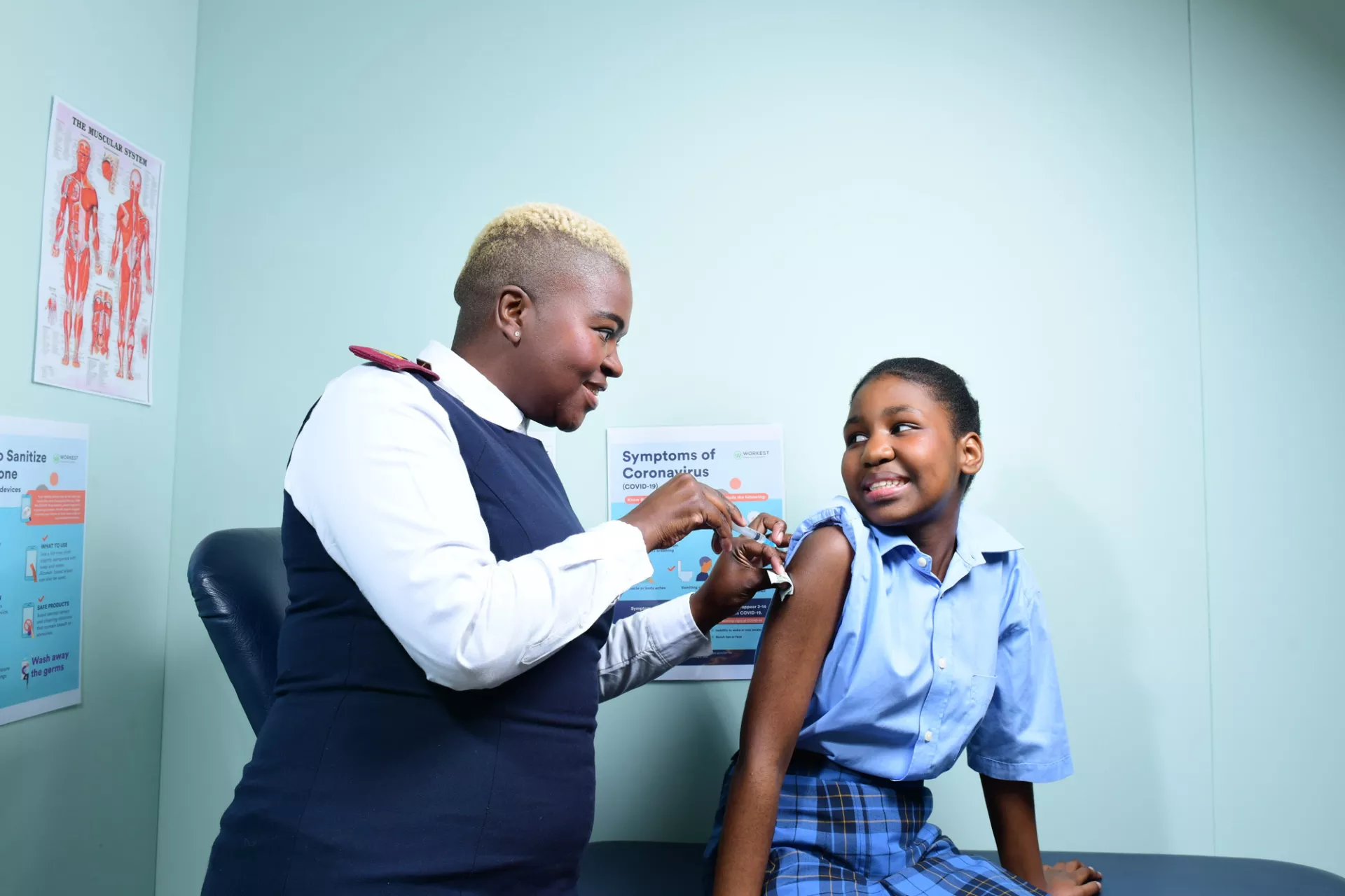 friendly nurse vaccinating smiling school girl
