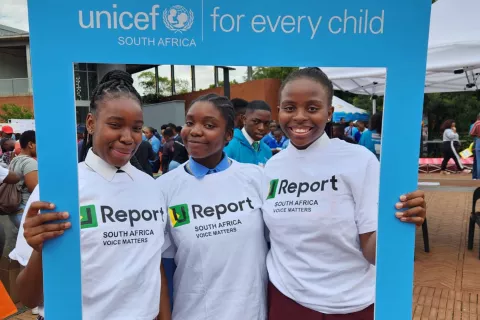 three smiling young females wearing U-report South Africa t-shirts