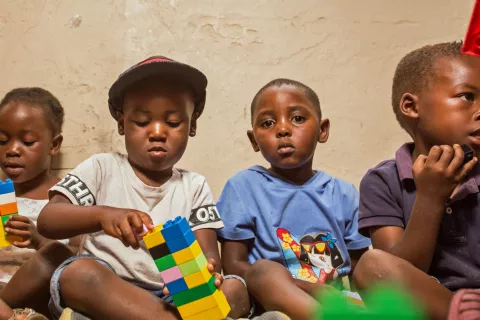 young children sitting on the floor playing with lego blocks