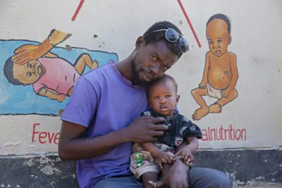 Father hugs his baby at a nutrition center.
