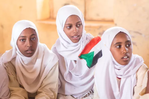 Three girls with Sudanese Flag