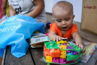 Infant playing with a UNICEF Magic Bag of books and toys