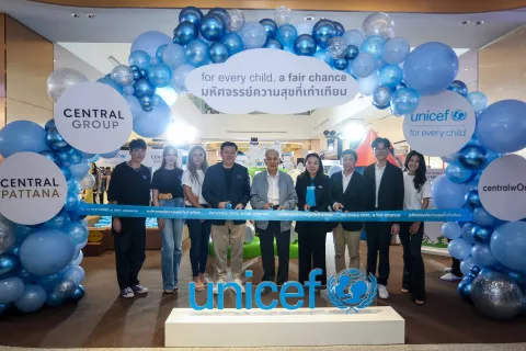 A group of people standing behind a ribbon-cutting ceremony setup with the UNICEF logo prominently displayed on a platform. The setting is adorned with blue and silver balloons. Signs reading "CENTRAL GROUP", "CENTRAL PATTANA", and "for every child, a fair chance" in both English and Thai script are also visible.