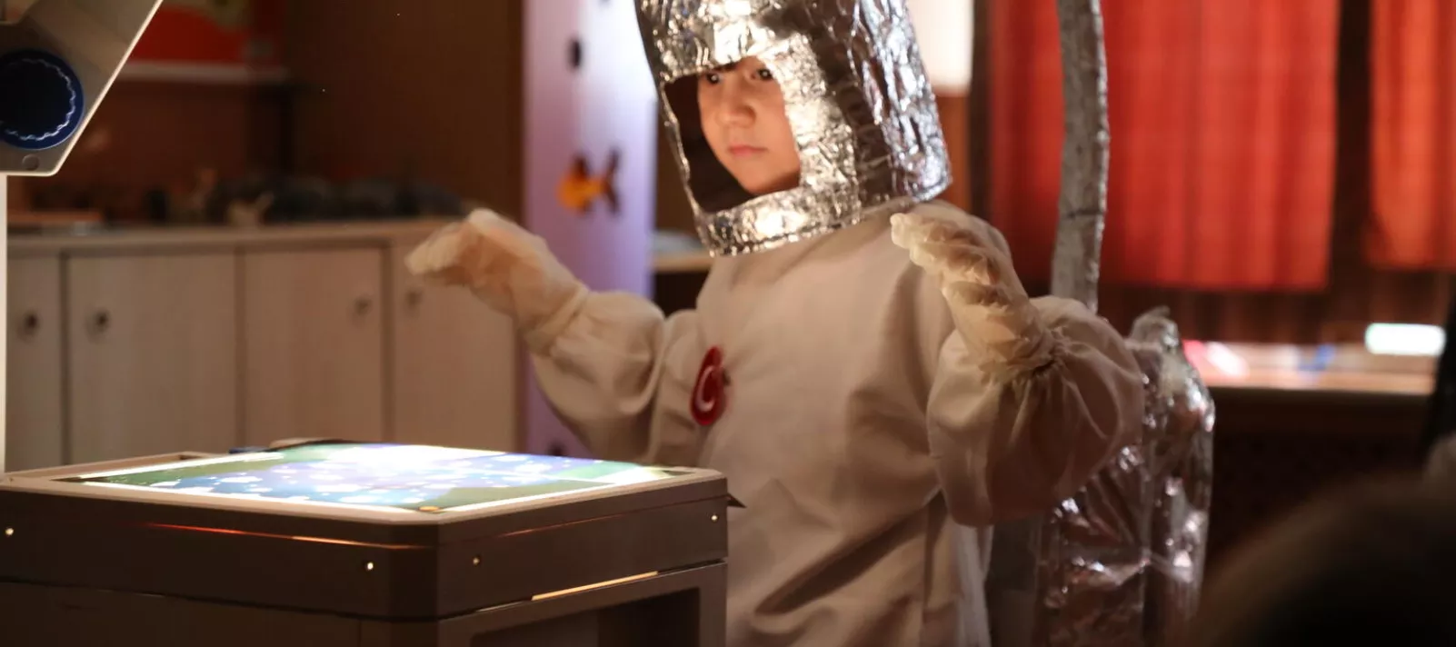 Child in a robot costume doing research