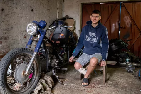 Ярослав (16), який втратив ступню через міну, сидить біля мотоциклу